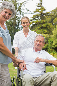 和护士和妻子一起坐在轮椅上快乐的男人图片
