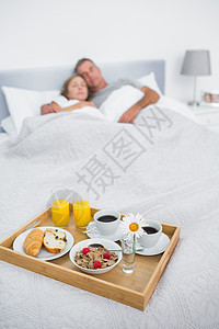 抱抱夫妇在床上用早餐盘睡觉图片