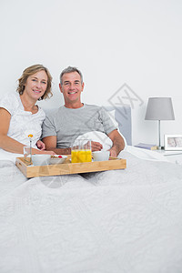 中年夫妇一起在床上吃早饭图片