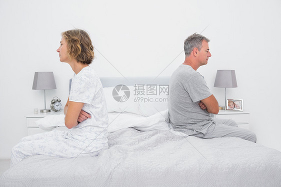 夫妻坐在床上的不同侧面 在争吵后不说话图片