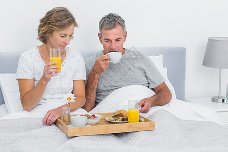 夫妻一起在床上吃早餐的快乐图片