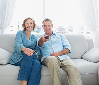 坐在沙发上看电视的中年夫妇们图片