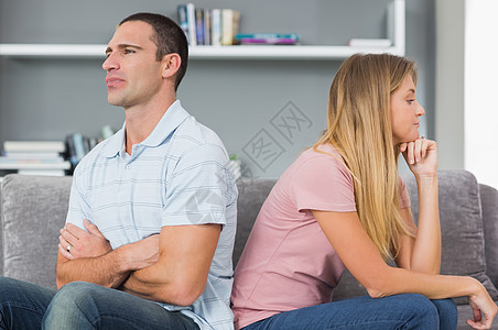 在沙发上打架后 一对情侣背靠背坐着裂痕分歧男性头发悲伤金发家庭争议房子长椅图片
