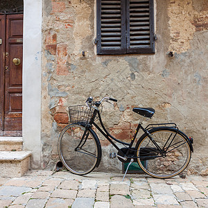 意大利式旧式自行车车轮古董金属座位城市棕褐色黑色石头胡同运输图片