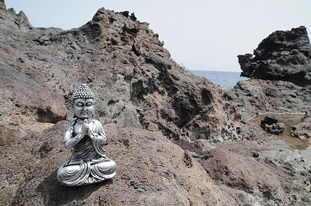 佛烟佛像雕像岩石上帝佛教徒男人海岸祷告太阳沙漠沉思热带背景