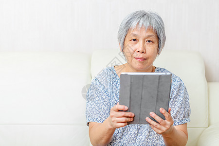 亚洲年老妇女带数字平板电脑退休学习老太婆技术药片老年男人老人女人白色图片