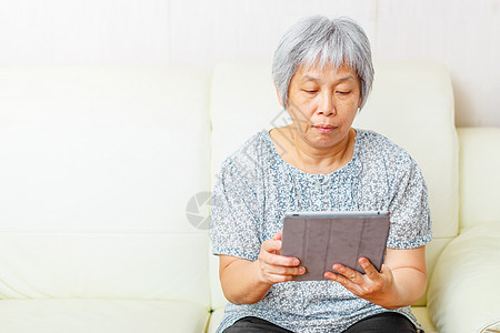 亚洲老年妇女使用数字平板电脑白色技术老太婆学习老人药片女人退休男人图片