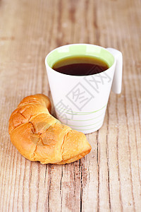 茶杯和新鲜的羊角面包脆皮白色小吃茶点早餐糕点液体棕色木头乡村图片