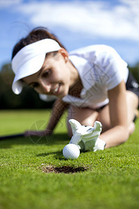 漂亮女孩在高尔夫球场作弊高尔夫球微笑草地玩家俱乐部爱好推杆游戏女孩运动图片