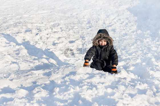 坐在雪上的小男孩闲暇雪服情绪化紧张手套情绪季节男人帽子蓝色图片