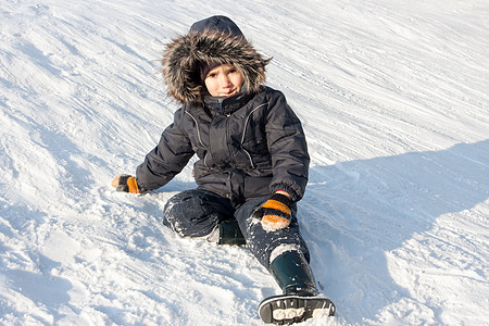 下雪的年轻男孩寒冷季节蓝色爬坡冷冻白色手套情绪童年孩子图片