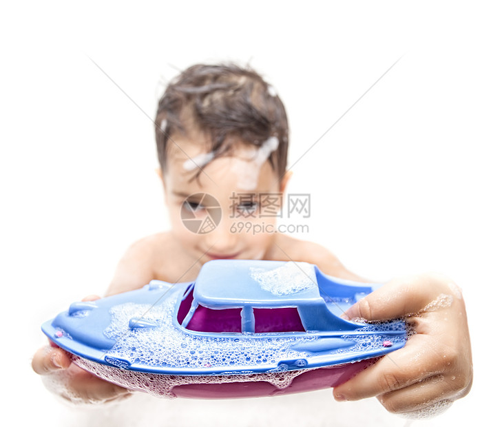 男孩与玩具船在浴缸里玩图片