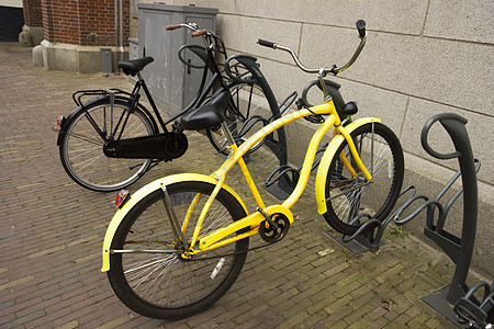 黄色自行车 停在自行车泊车处的平板轮胎运输行动学校踏板运动活动速度框架车轮图片