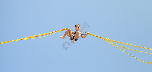 男孩跳跃在蹦床线上乐趣逗乐活动灵活性天空游乐场幸福行动运动娱乐图片