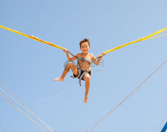 男孩跳跃在蹦床线上公园行动乐趣体操游乐场蓝色活力身体安全绳索图片