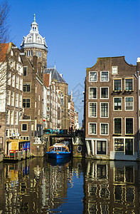 阿姆斯特丹频道上的蓝色船 典型的阿姆斯特丹建筑师特丹日光石工建筑树木自行车塔钟摄影住宅场景图片