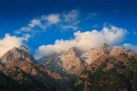 日落时云中喜马拉雅高峰会图片