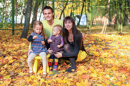 年轻的父母带着两个小女儿在黄秋公园享受天气图片
