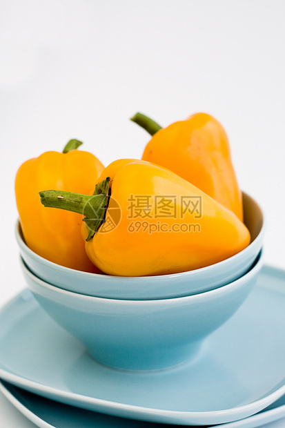 三个黄黄甜辣椒在蓝盘上饮食陶瓷食物小吃美食黄色蓝色蔬菜胡椒早餐图片