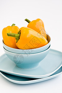 三个黄黄甜辣椒在蓝盘上早餐蔬菜蓝色餐具胡椒饮食食物黄色美食陶瓷图片