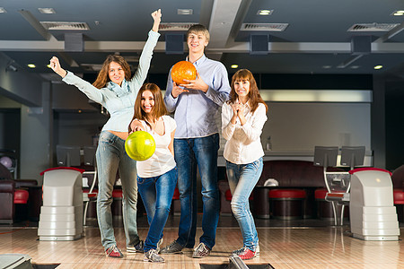 一群玩保龄球的年轻朋友成人女孩男人竞赛运动爱好欢呼投掷游戏牛仔裤图片