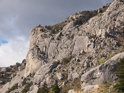 山岳和云云针叶天空石质多云绿色季节石头牧歌岩石植物图片