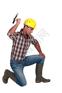 使用锤子的建筑工人石匠人行道建造石工安全帽修理建设者男人手臂工作图片