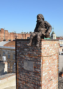 铁人坐在屋顶上城市蓝色男人雕塑棕色建筑学图片