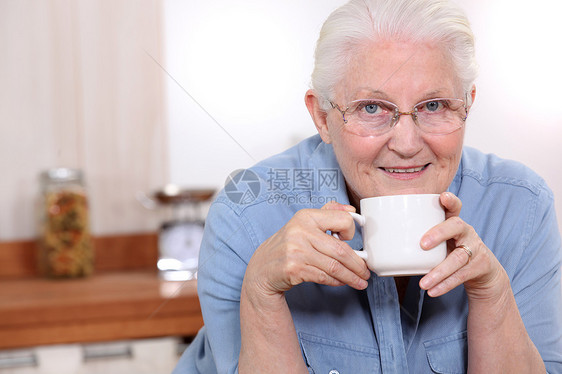 年长的女士在厨房喝茶图片