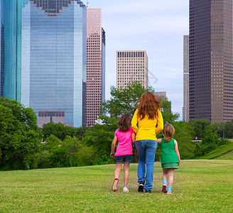 母亲和女儿们在城市天线上举手走路地标孩子们建筑物公园建筑学姐妹蓝色家庭办公室旅行图片