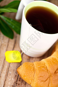 茶杯和新鲜的羊角面包脆皮液体植物咖啡糕点食物茶点茶包杯子雏菊图片