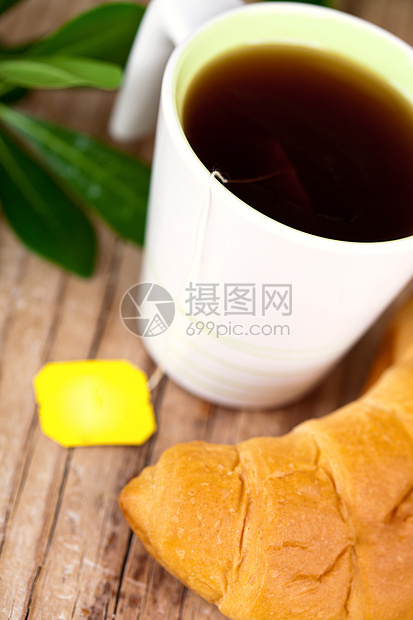 茶杯和新鲜的羊角面包脆皮液体植物咖啡糕点食物茶点茶包杯子雏菊图片