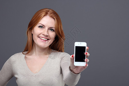 美丽的年轻女子电话快乐女性营销成人广告微笑技术女士红发图片