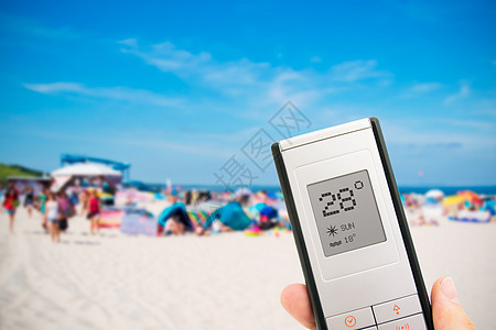 持有电子温度计的手持电子温度计 在海滩上的人背景图片