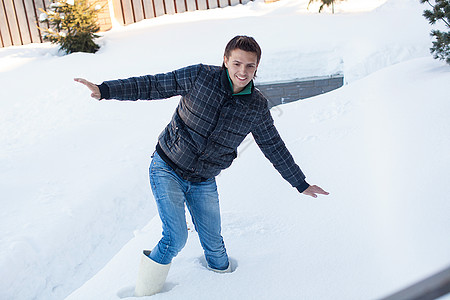 穿冬靴的年轻男子 坠落在深白雪中假期休息鞋类蓝色男人季节爬坡男性森林小路图片