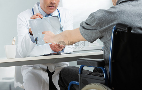 向病人提供X光的医生服务轮椅中年医护人员诊所考试疾病检查医院职业图片
