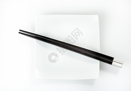 在白色背景上被孤立的板块上的筷子餐具盘子图片