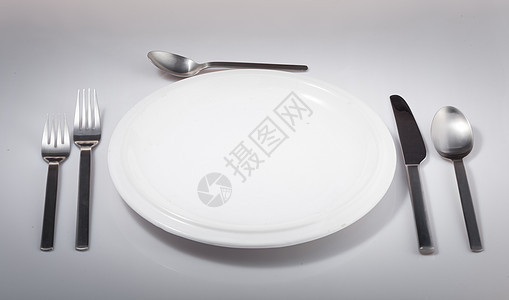 白背景上孤立的空银勺子白色盘子刀叉餐具刀具圆形图片