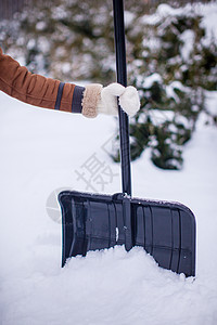 冬天天 一个年轻女人把铁铲拿在雪中图片