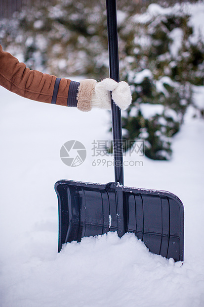 冬天天 一个年轻女人把铁铲拿在雪中图片