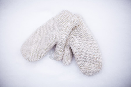 白色雪上的柔软 温暖 编织的手套图片