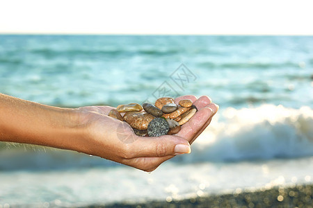 女性手中的海洋卵石图片