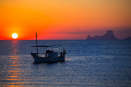 伊比扎日落Es Vedra 观景和渔船浮游船太阳橙子日落海岸假期天堂胰岛血管天空地标图片