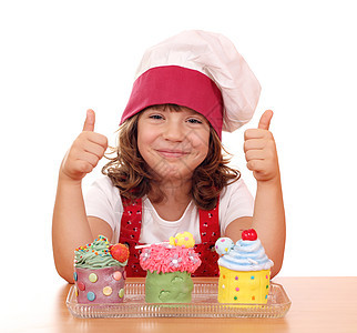 快乐的小女孩做饭 用纸杯蛋糕和拇指图片
