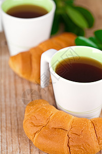 两杯茶和两杯新鲜的羊角面包糕点早餐食物甜点乡村脆皮咖啡植物液体杯子图片