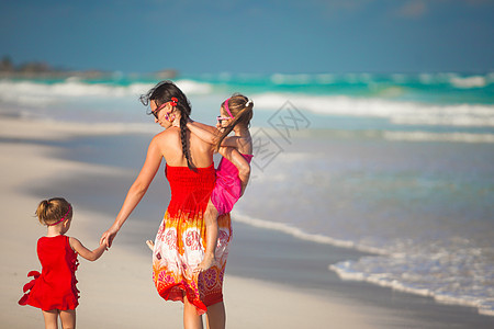 母亲和两个可爱的女儿 在阳光明媚的白天在异国海滩散步父母婴儿热带女孩假期妈妈晴天孩子海岸女性图片