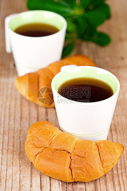 两杯茶和两杯新鲜的羊角面包甜点脆皮茶点早餐木头食物小吃叶子杯子液体图片