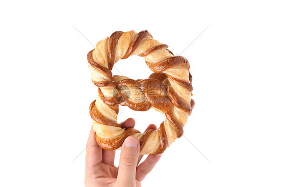 手握着结结状的饼干营养早餐包子脆皮美食面包师宏观小麦食品面包图片