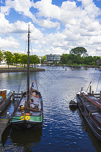 许多停泊在阿姆斯特丹岸边的船只运输倾倒驳船航海码头血管窗户房子桅杆生活图片
