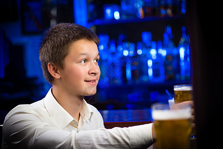 酒吧一位年轻人的肖像饮料夜生活娱乐讨论蓝色辩论男性朋友们酒精玻璃图片